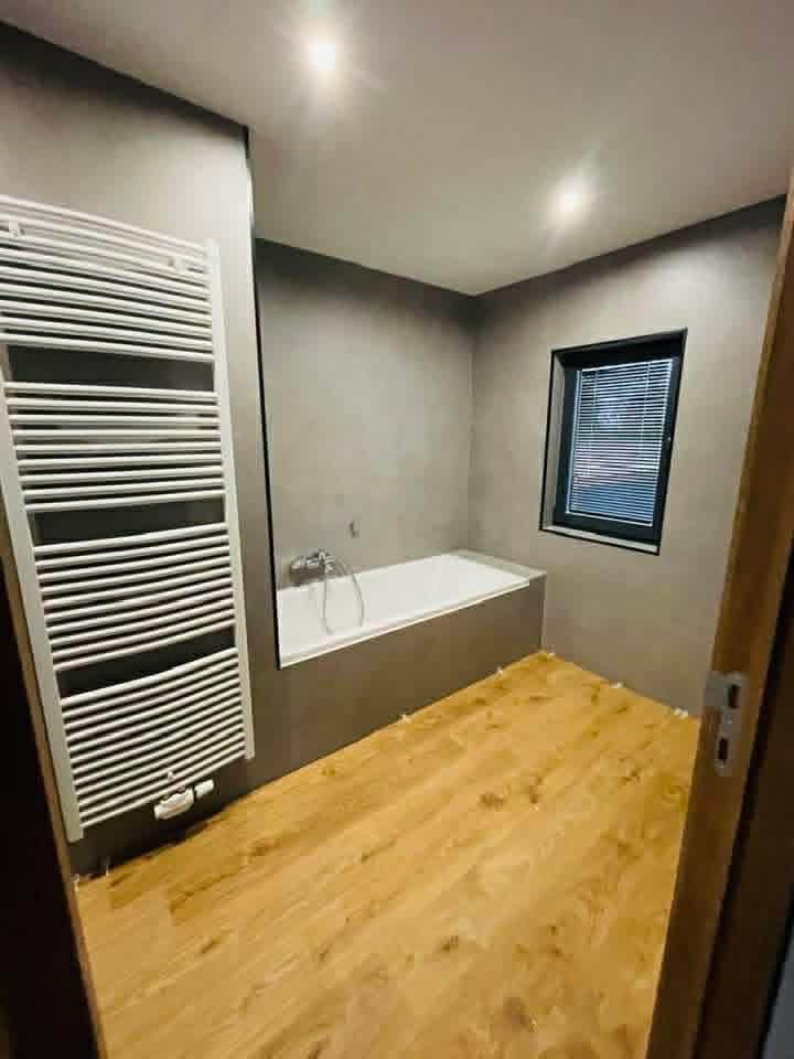 Salle de bain avec baignoire et parquet